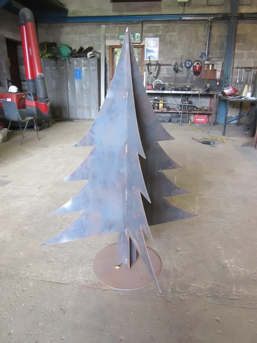 Freestanding stylised steel fir tree on a circular base